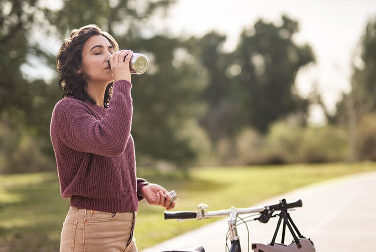 Adult woman standing on outdoor cycling path with bike